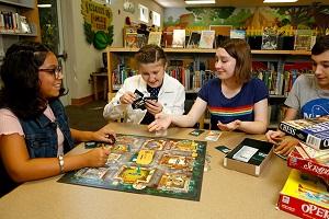 Four teenagers playing a board game together