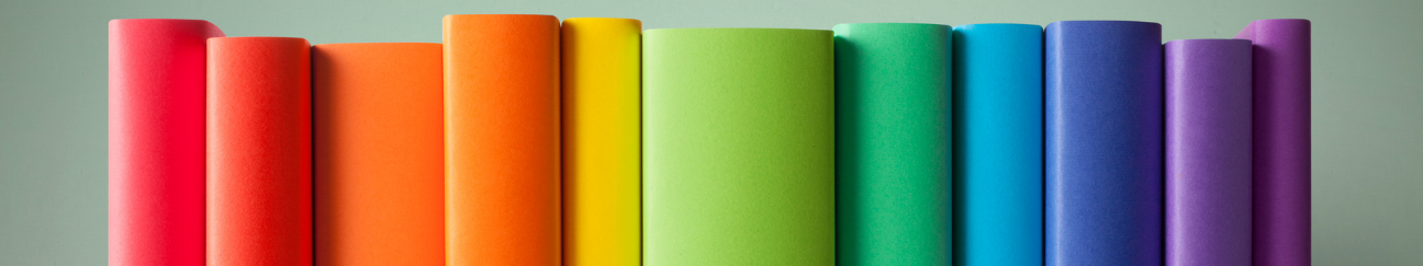 A long thin banner with a muted green background. In the foreground are eleven book spines in rainbow colors.