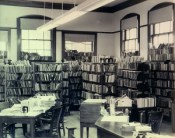 old black and white photograph of the inside of the library from 1918-1956 with desks and chairs and bookshelves in the background