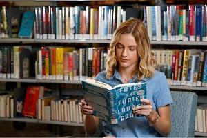 person reading a book in the library