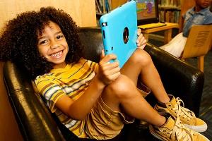 Child using a tablet in the library