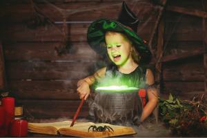 Girl witch holding a wand by a cauldron