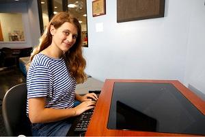 someone looking up and smiling while sitting at a computer workstation