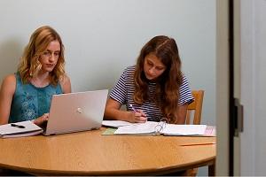 two people sitting at a table in a meeting room