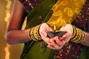 Photo of woman in a sari holding a light