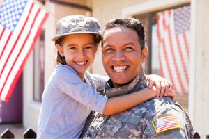 Father in military uniform holding child