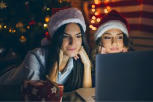 Two women watching a movie on a computer 