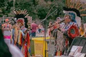 Native Americans playing flutes in traditional dress