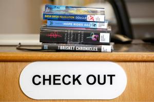 stack of books over a checkout counter