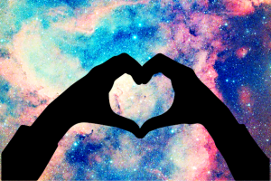 black shadow of two hands in the shape of a heart with a colorful background of blue and red shades