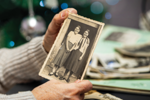 Hands holding old photograph of two girls.