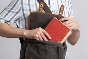 Man putting book in bag