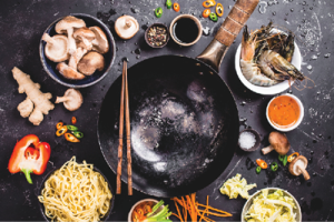 display of Asian food in bowls around a frying pan