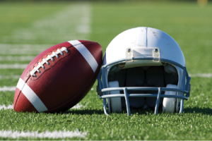 football leaning on a helmet on the field