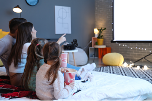 a family watching a large home theater screen