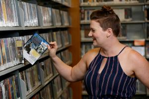 someone selecting a DVD from the library shelves