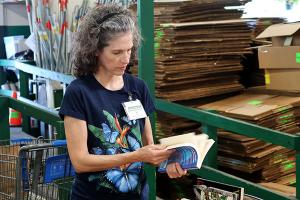 A woman flips through a book at the Friends of the Library book sale