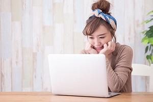 someone viewing their laptop screen and smiling
