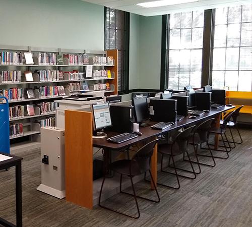 Row of computers and a book shelf at the Micanopy Branch