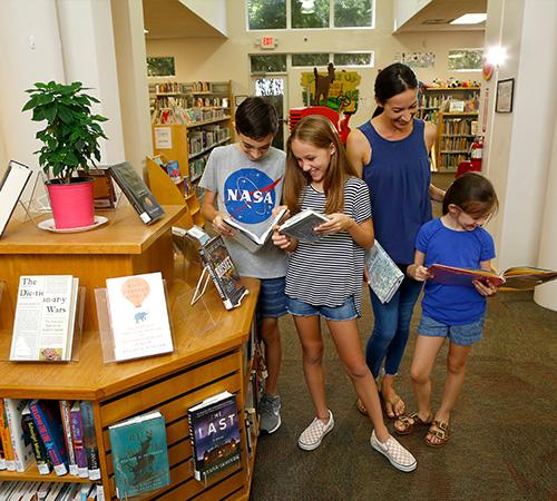 Family reading books at the Newberry Branch