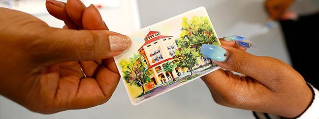 Library card being handed from one person to another