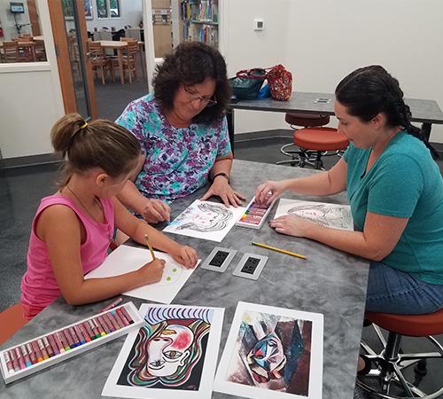 Women and child painting in the Waldo Branch Art Space