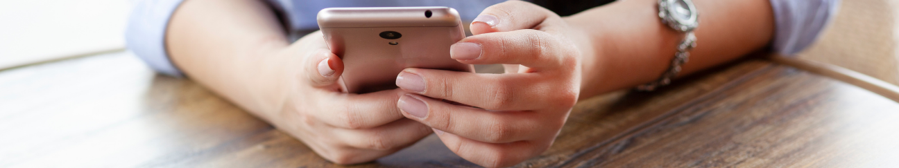 header of hands holding phone