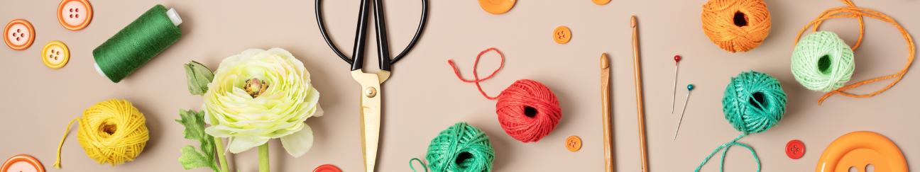 A long thin banner. It is a photo with a beige background with various craft materials and tools. 