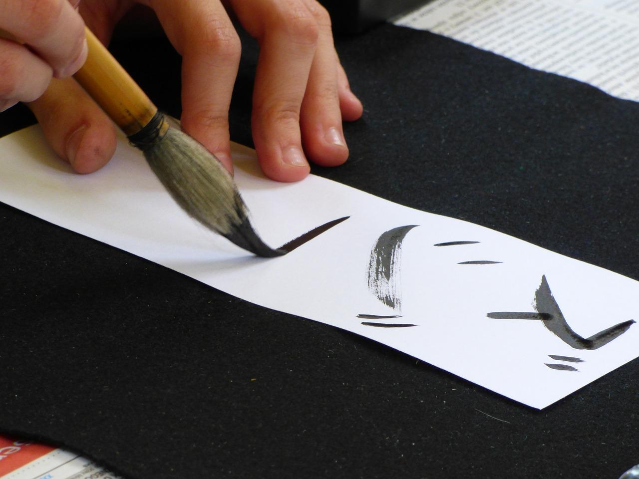 person writing Japanese calligraphy