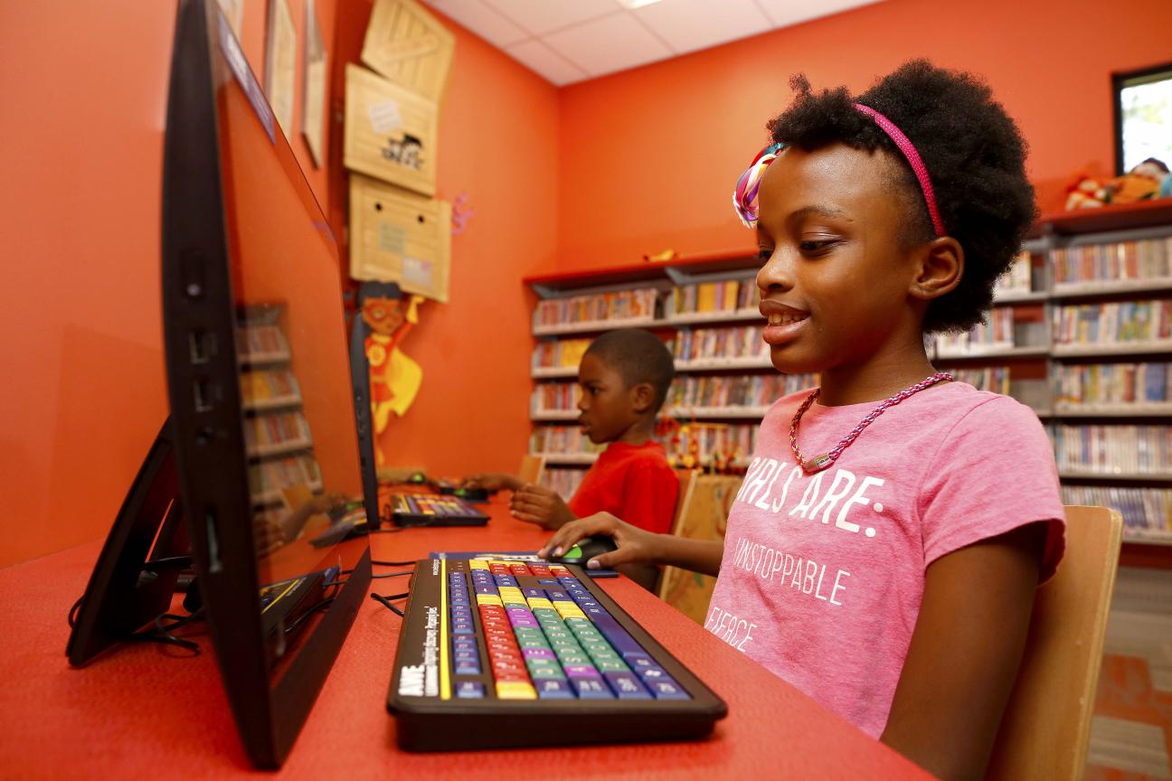 A photo of a young girl sitting at a computer.