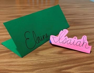 Piece of folded paper with "Elaine" in cursive along the folded edge.