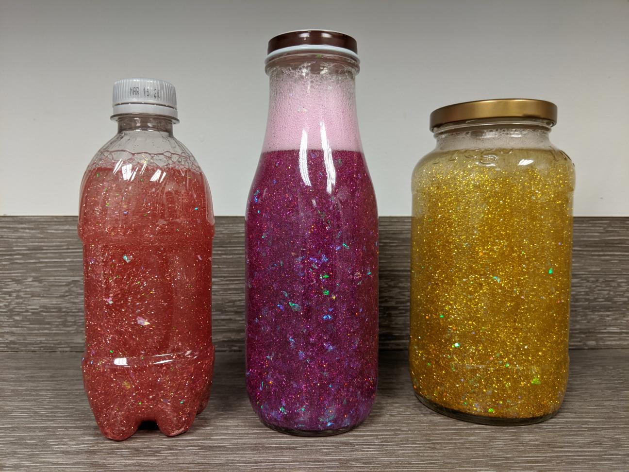 3 Calming Glitter Jars 3 calming glitter jars: a small pink one, a larger pink one, and a medium gold one.