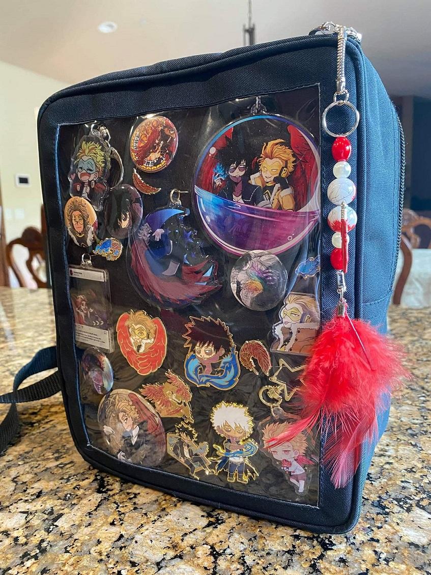 picture of a black ita bag with pins and buttons displayed