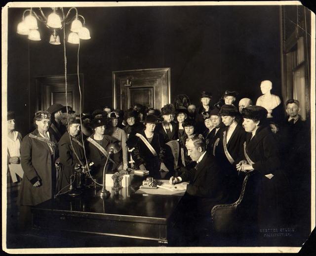 photograph of Kentucky Governor Edwin P. Morrow signing the 19th amendment with women surrounding him