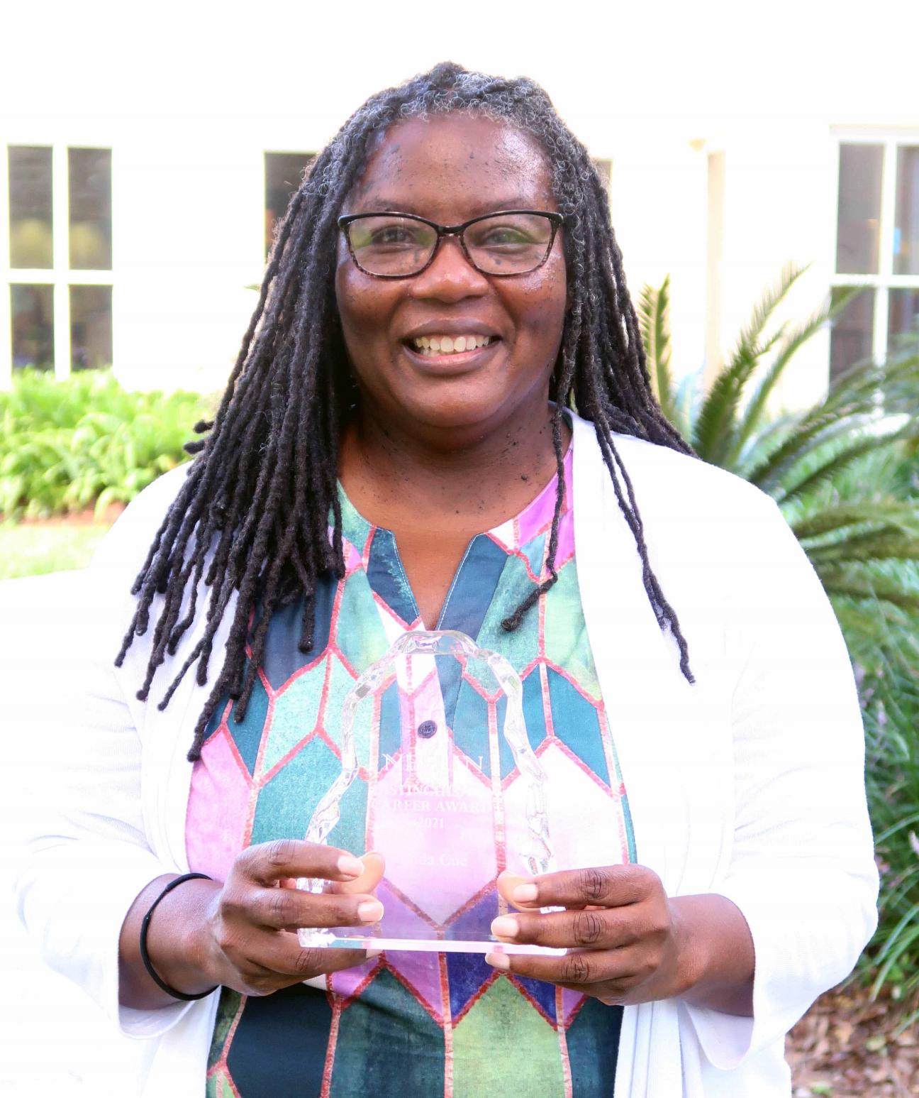 Librarian Linda Cue holds her award. 