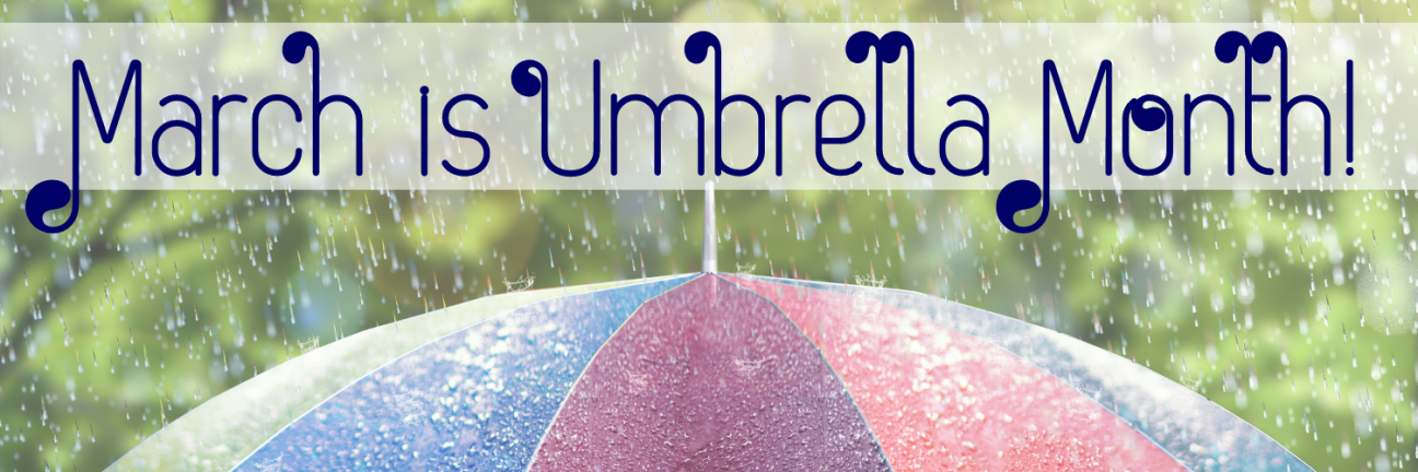 The words "March is Umbrella Month" in a dark blue font on a slightly transparent white rectangle, superimposed on top of a photo of the top of a rainbow colored open umbrella in a sun shower.