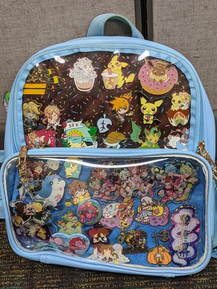 picture of a light blue ita bag with video game charms and Pins 