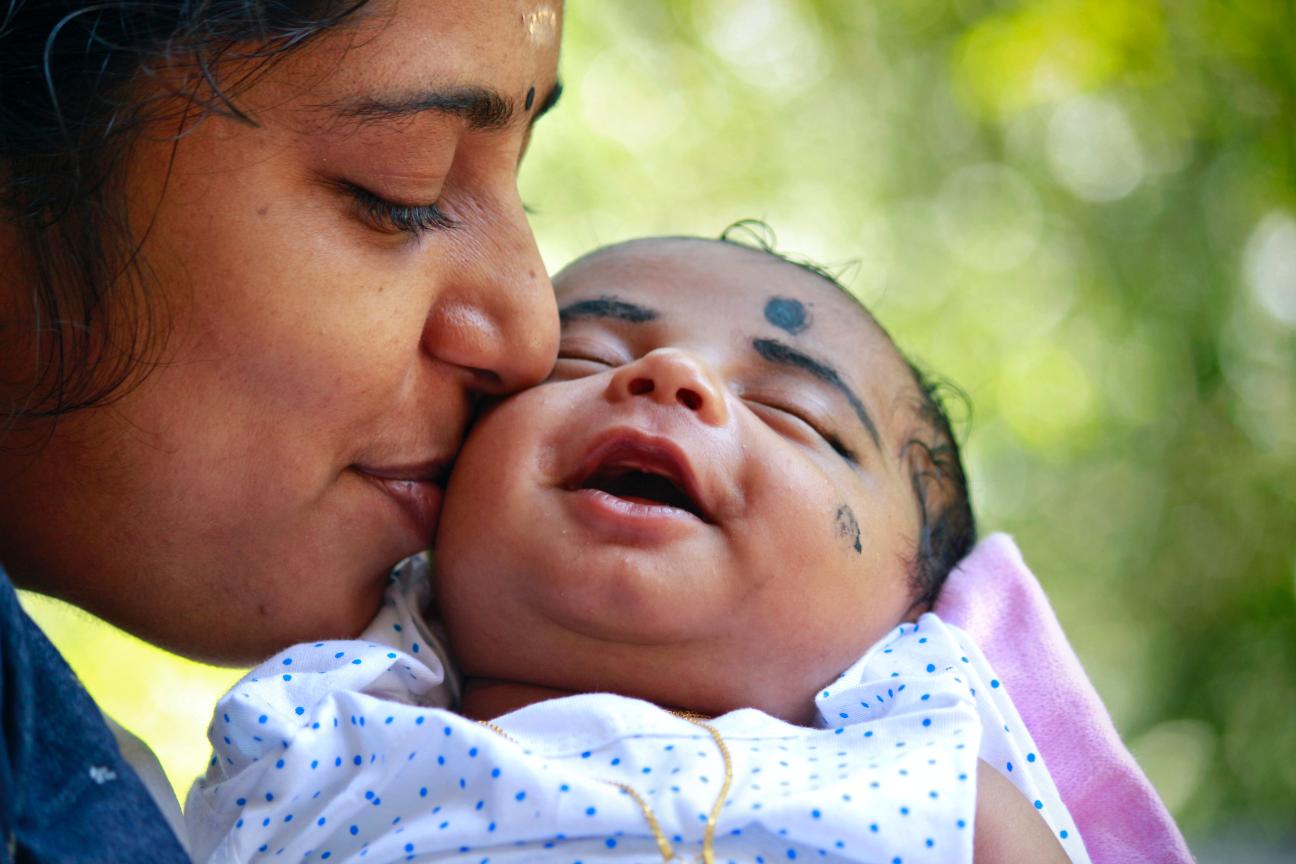 Mother kissing child on cheek Mother kissing child on cheek