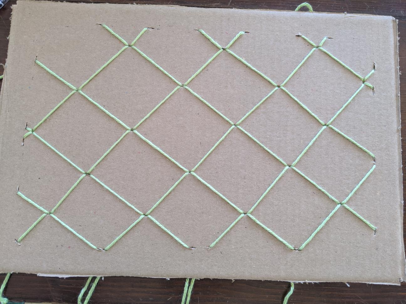 The same board from before, with the overlapping yarn points sercured on the back of the board with a toothpick.