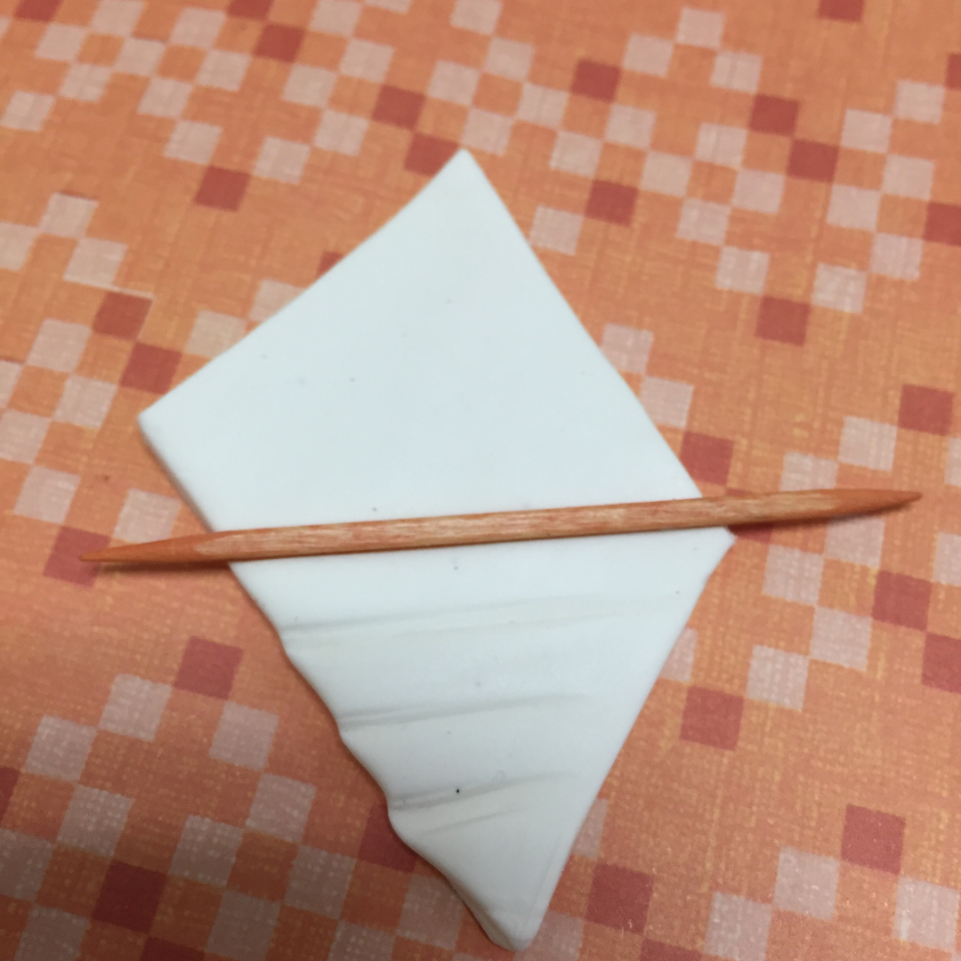 Pressing a toothpick into the moist clay of the aromatherapy diffuser to create decorative lines Pressing a toothpick into the moist clay of the aromatherapy diffuser to create decorative lines