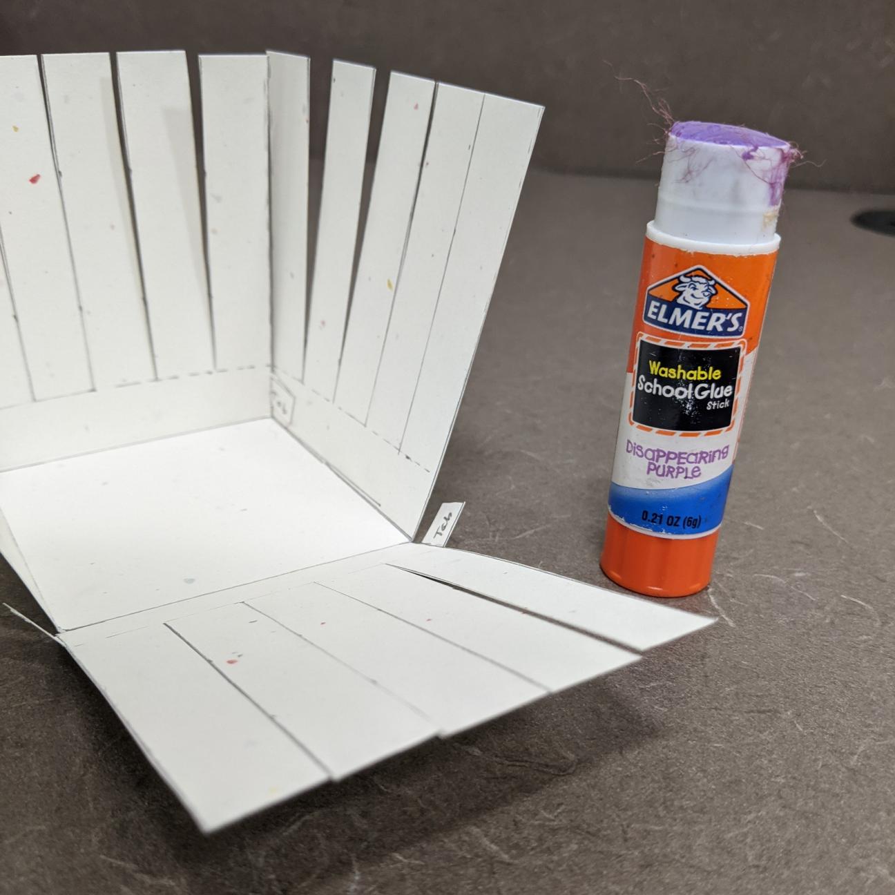Glue your basket together A picture of a paper basket, half glued together