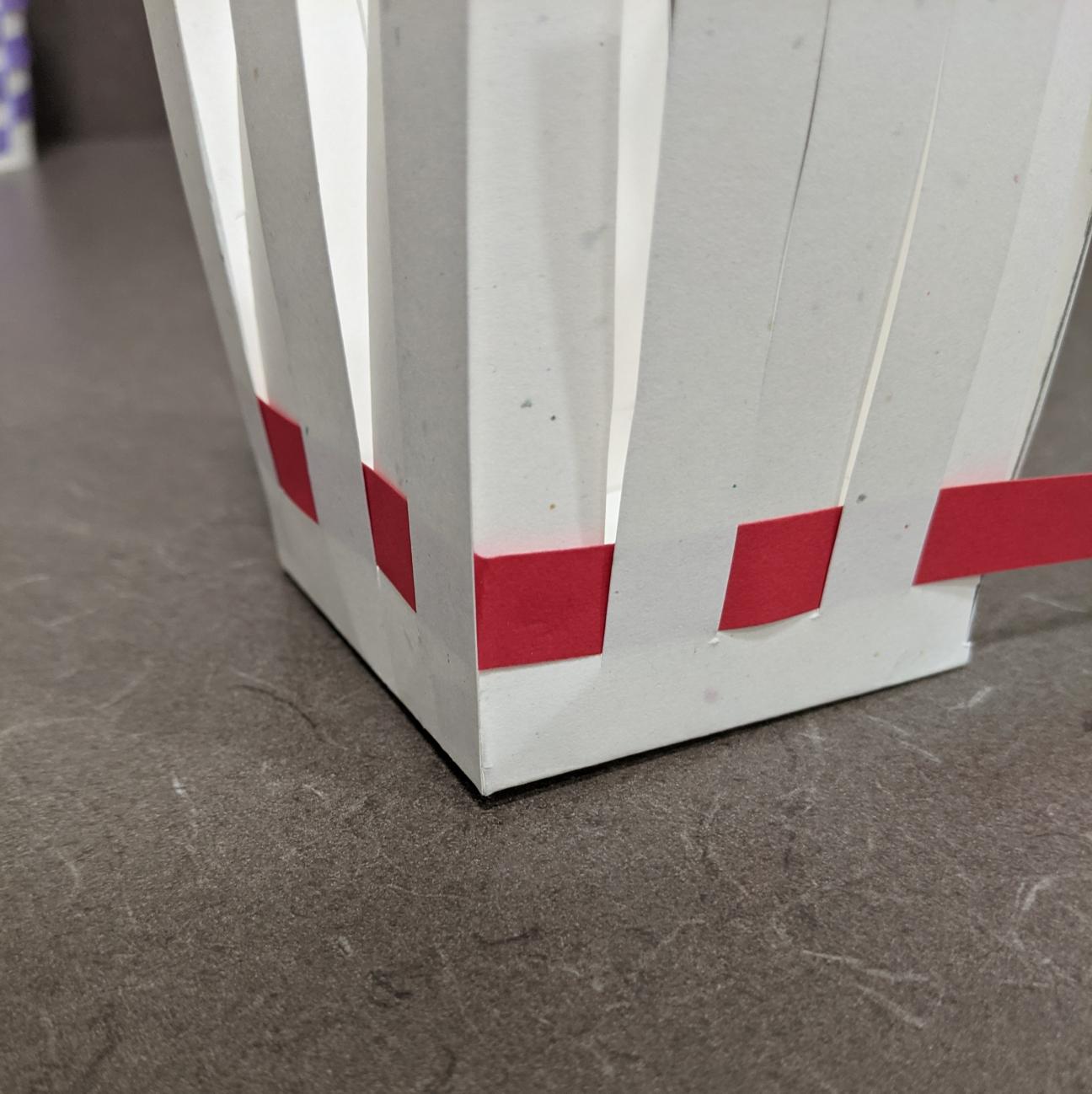Make a crisp corner The corner of the paper basket, where the strip of paper has been folded into a right angle