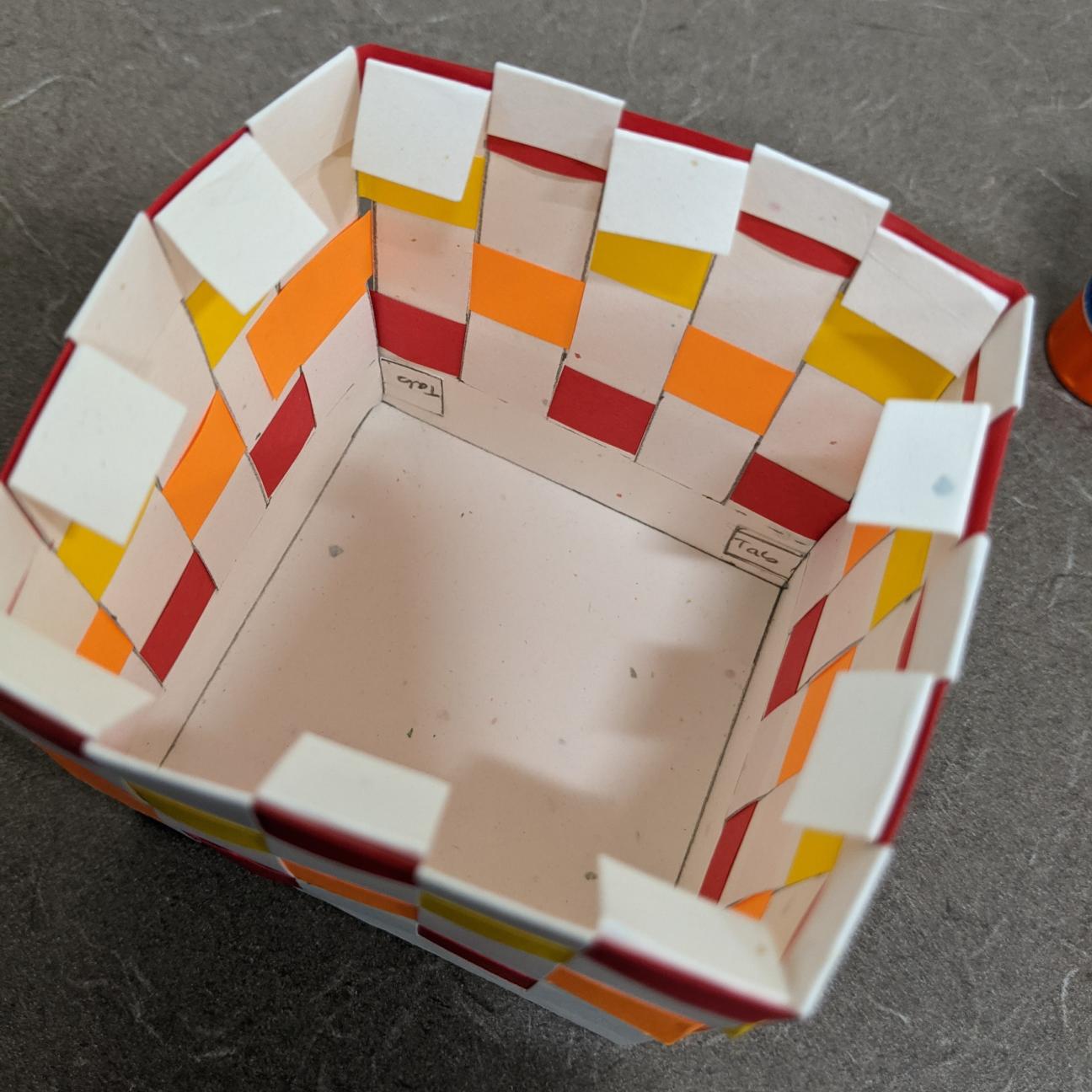 Fold your extra white paper down The paper basket, with the extra edges of white paper folded down, ready to be glued