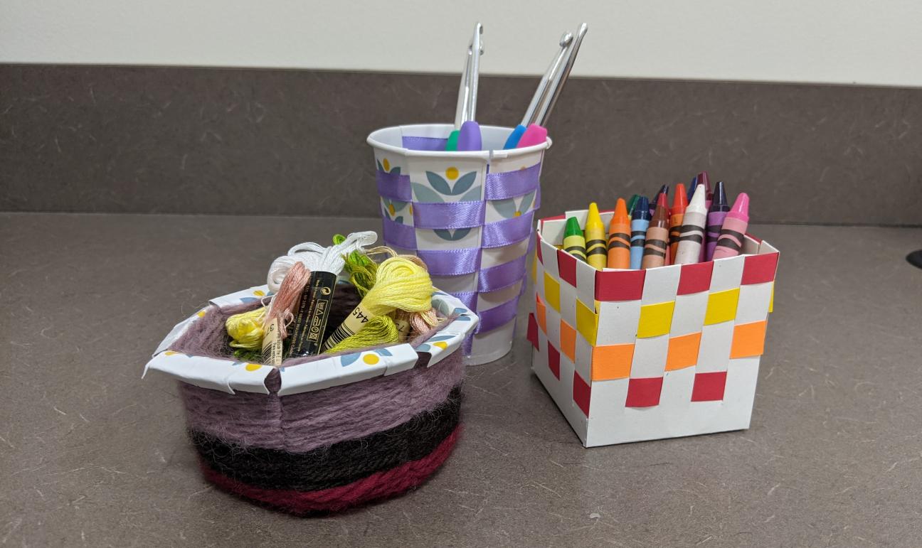 Different Types of Baskets A picture of three baskets. One is made from a paper plate and yarn. Another is tall and made from a paper cup and ribbon. The last is a square and made with white and colored paper