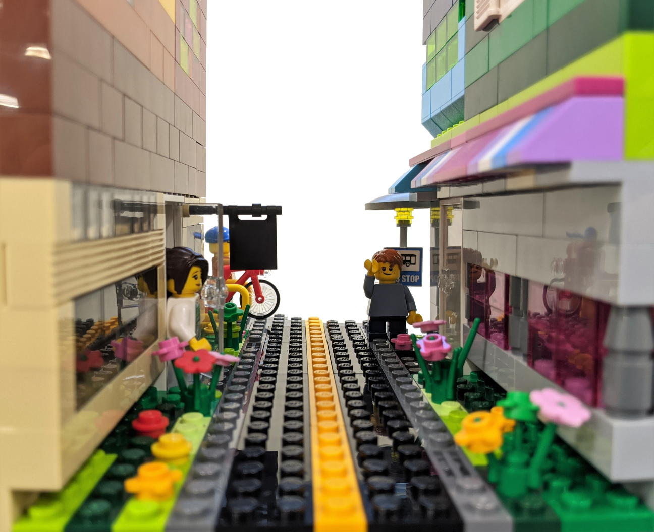 A close up photo of a LEGO book nook, showing a scene of a street with tall buildings on either side