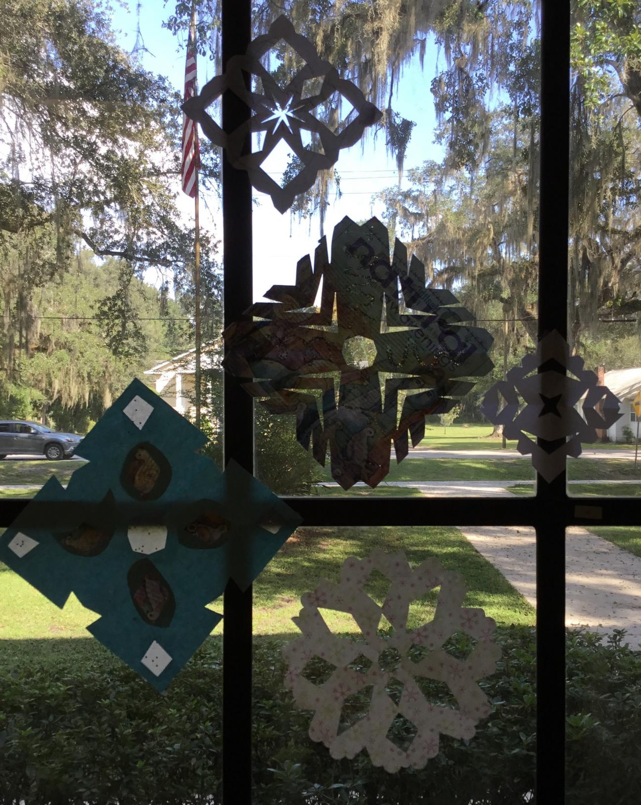 Paper Snowflakes Decorating a Window paper snowflake craft for elementary children