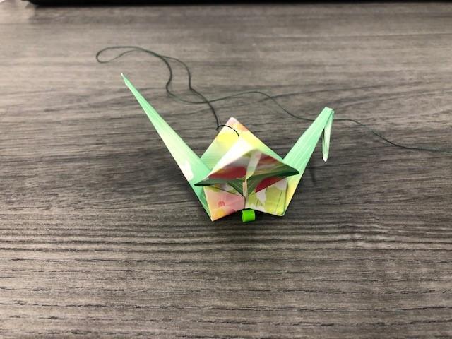 A needle being pushed through a paper crane