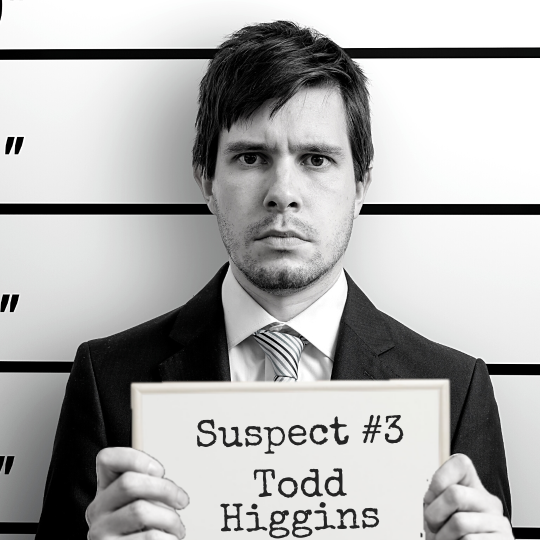 Suspect #3: Todd Higgins Black and white mugshot of a man in a business suit holding up a board that says "Suspect #3: Todd Higgins"