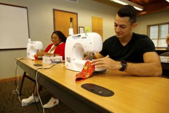 Man and woman using sewing machines