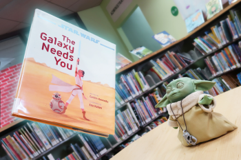 Grogu figure at the library with a hovering book